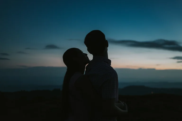 Novios abrazándose al amanecer durante una sesión de fotografía de bodas con luz natural y estilo documental.