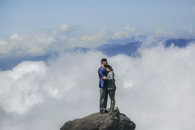 Fotografía de bodas de dos novios abrazándose sobre una roca en el Iztaccíhuatl, con un cielo cubierto de nubes que crea un paisaje imponente y una composición editorial de estilo fine art.