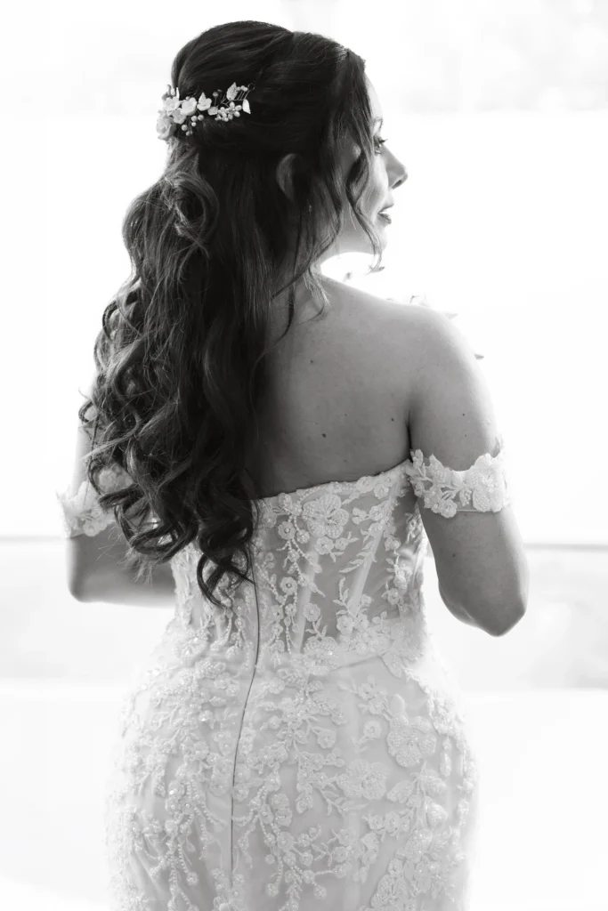 Retrato de novia de espaldas con vestido de novia sobre un fondo blanco. Fotografía editorial de bodas con una composición minimalista, luz suave y un estilo elegante que resalta la silueta y los detalles del vestido.